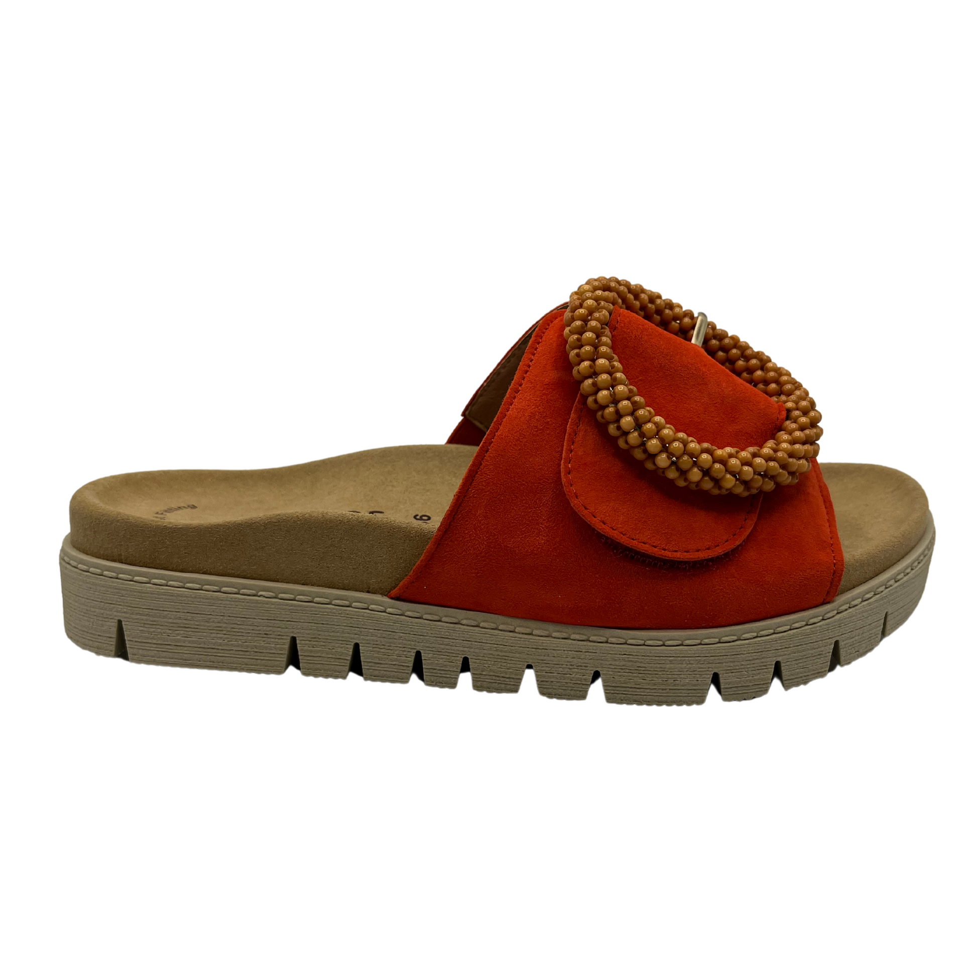 Right facing view of orange suede slide with large buckle detail and anatomical footbed