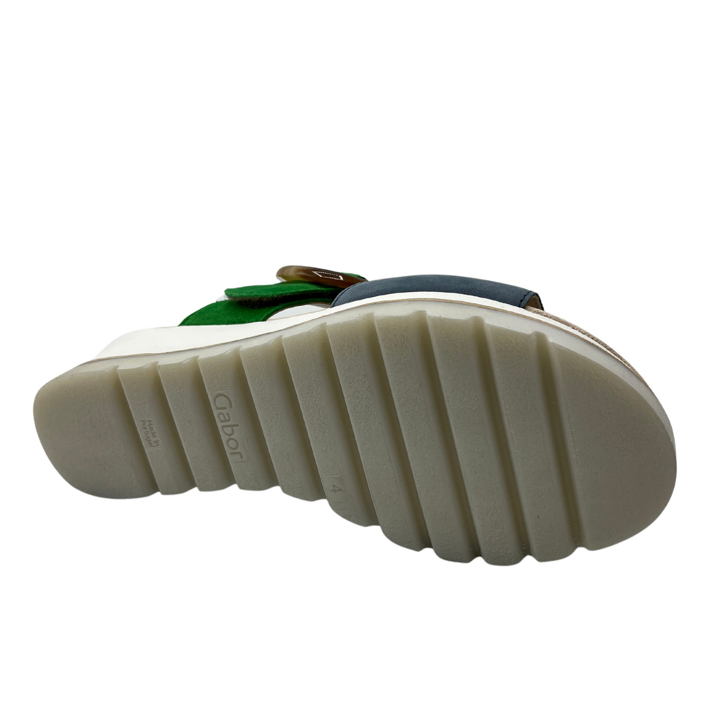 Bottom view of green and blue wedge sandal with white rubber outsole