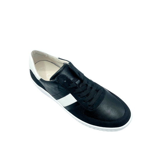 Angled front view of a black leather fashion sneaker with a white stripe in the middle and white cap on the heel.