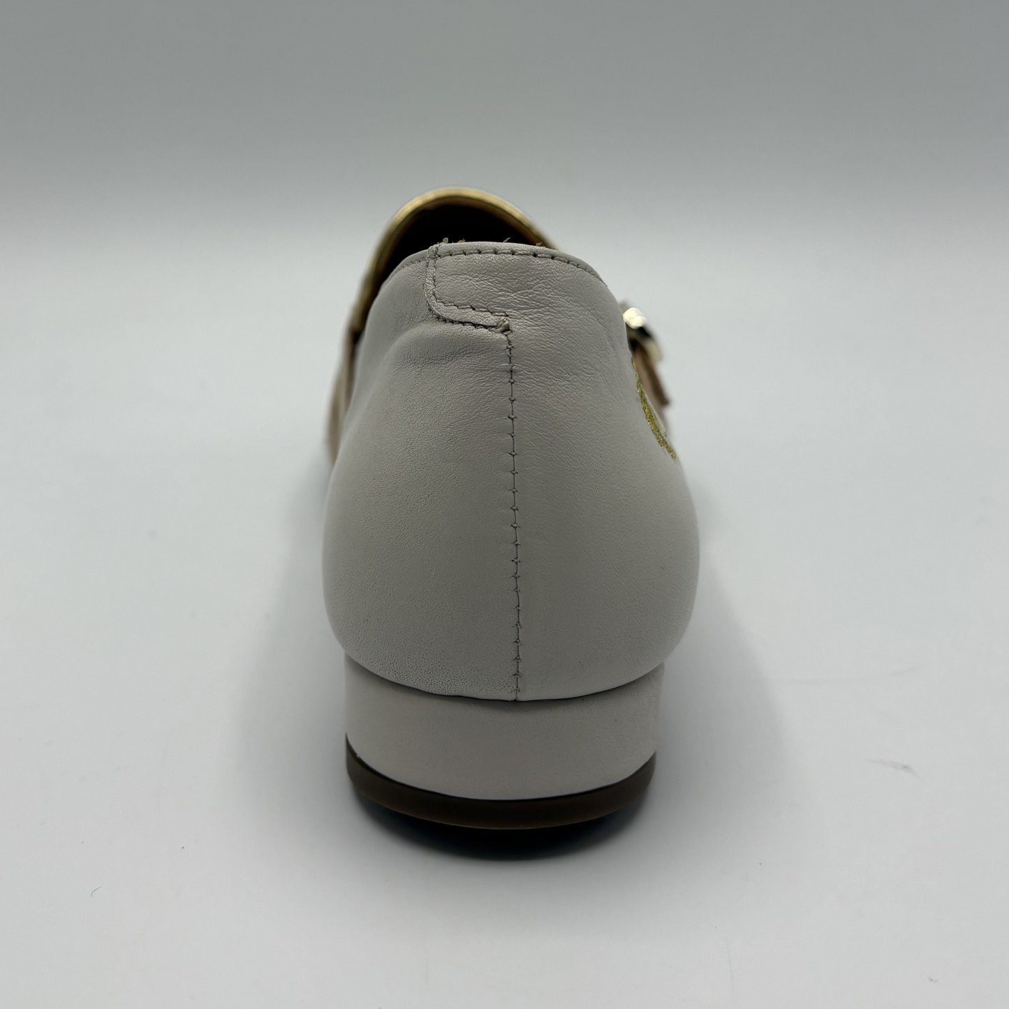 Back view of a beige loafer with buckle strap details