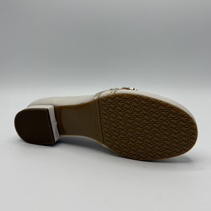 Bottom view of a beige loafer with buckle strap details