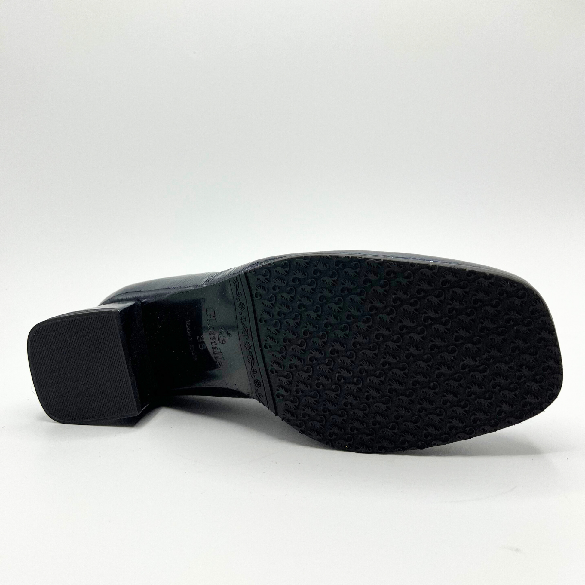 Bottom view of a navy leather loafer with a cream accent panel