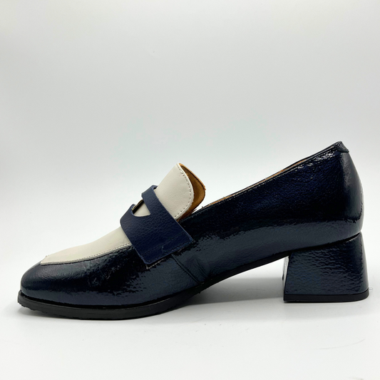 Left facing view of a navy leather loafer with a cream accent panel