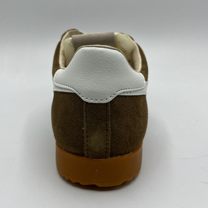 Brown shoe with white sole on a light gray background