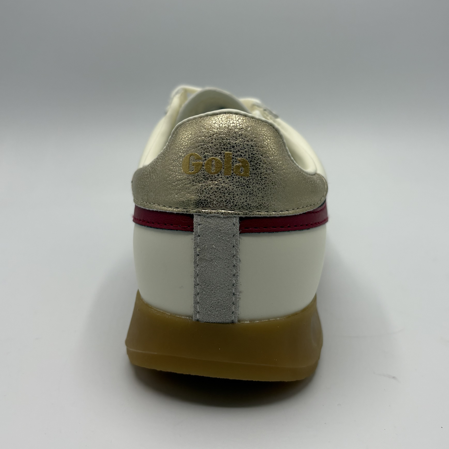 White sneaker with gold 'Gola' branding on a gray background