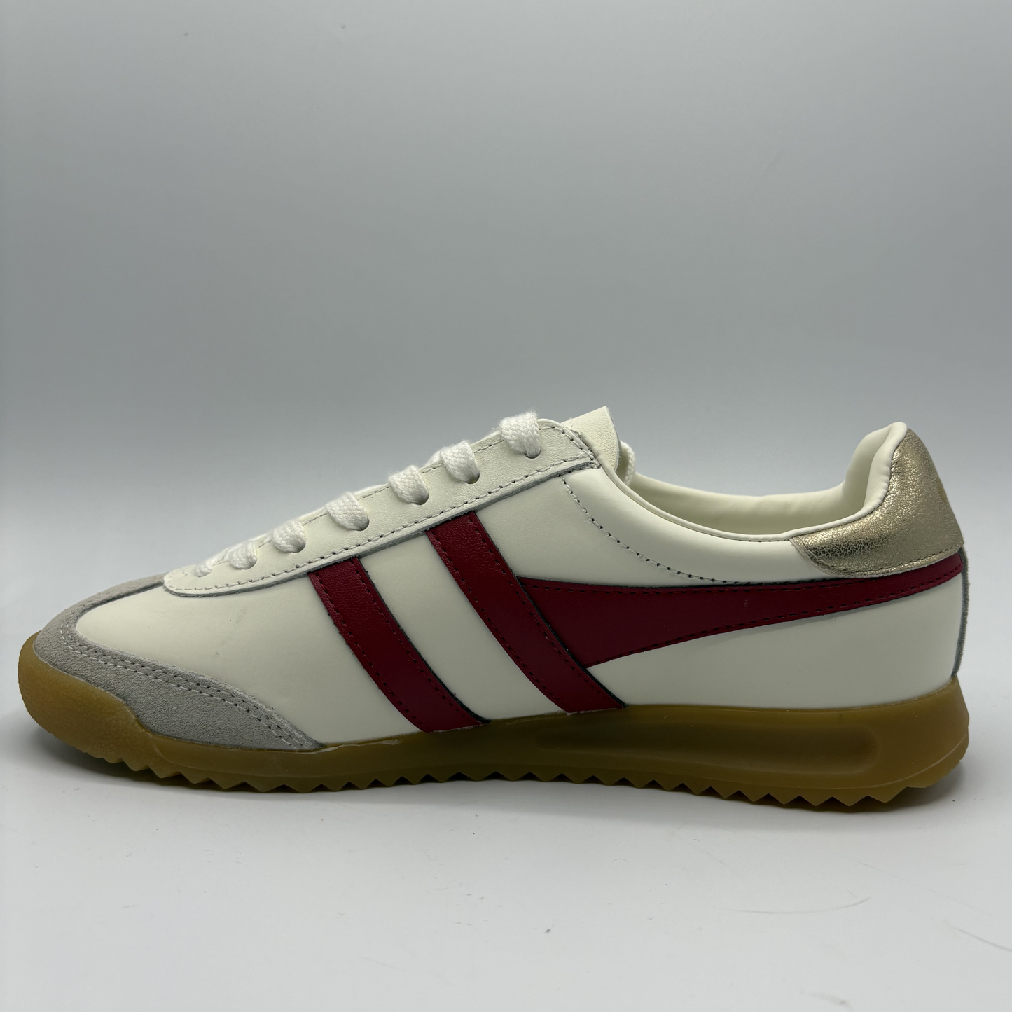 White sneaker with red stripes on a gray background