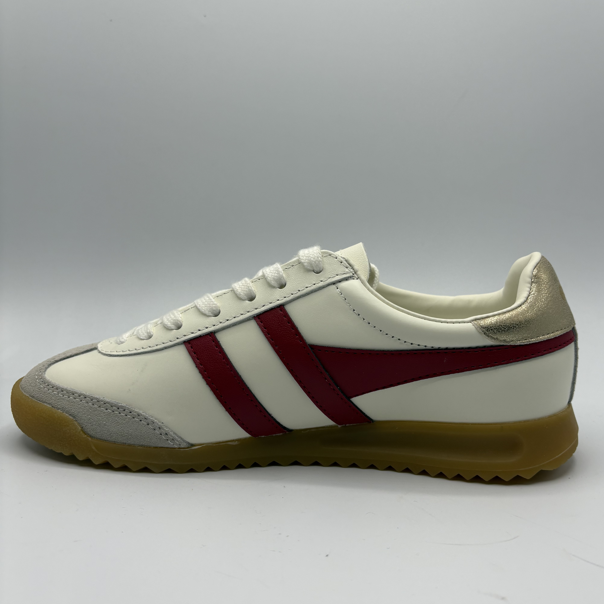 White sneaker with red stripes on a gray background