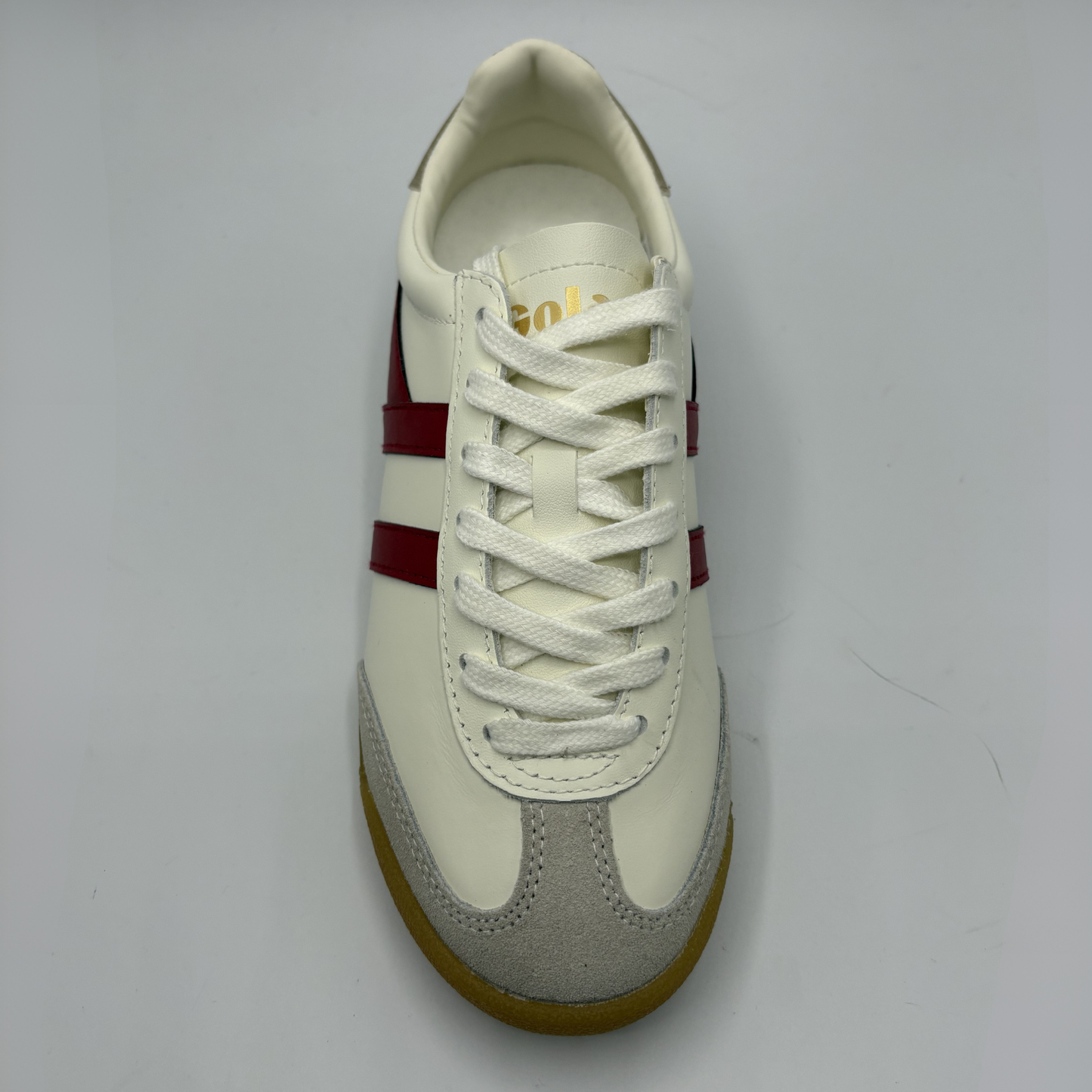 White sneaker with a red stripe on a gray background