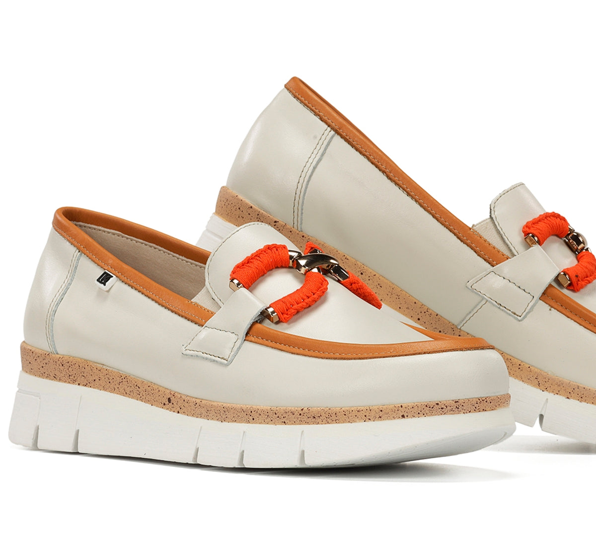 White loafers with orange accents on a white background