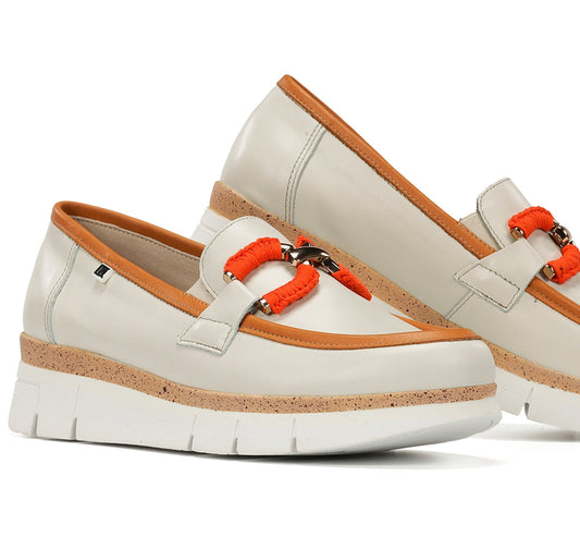 White loafers with orange accents on a white background