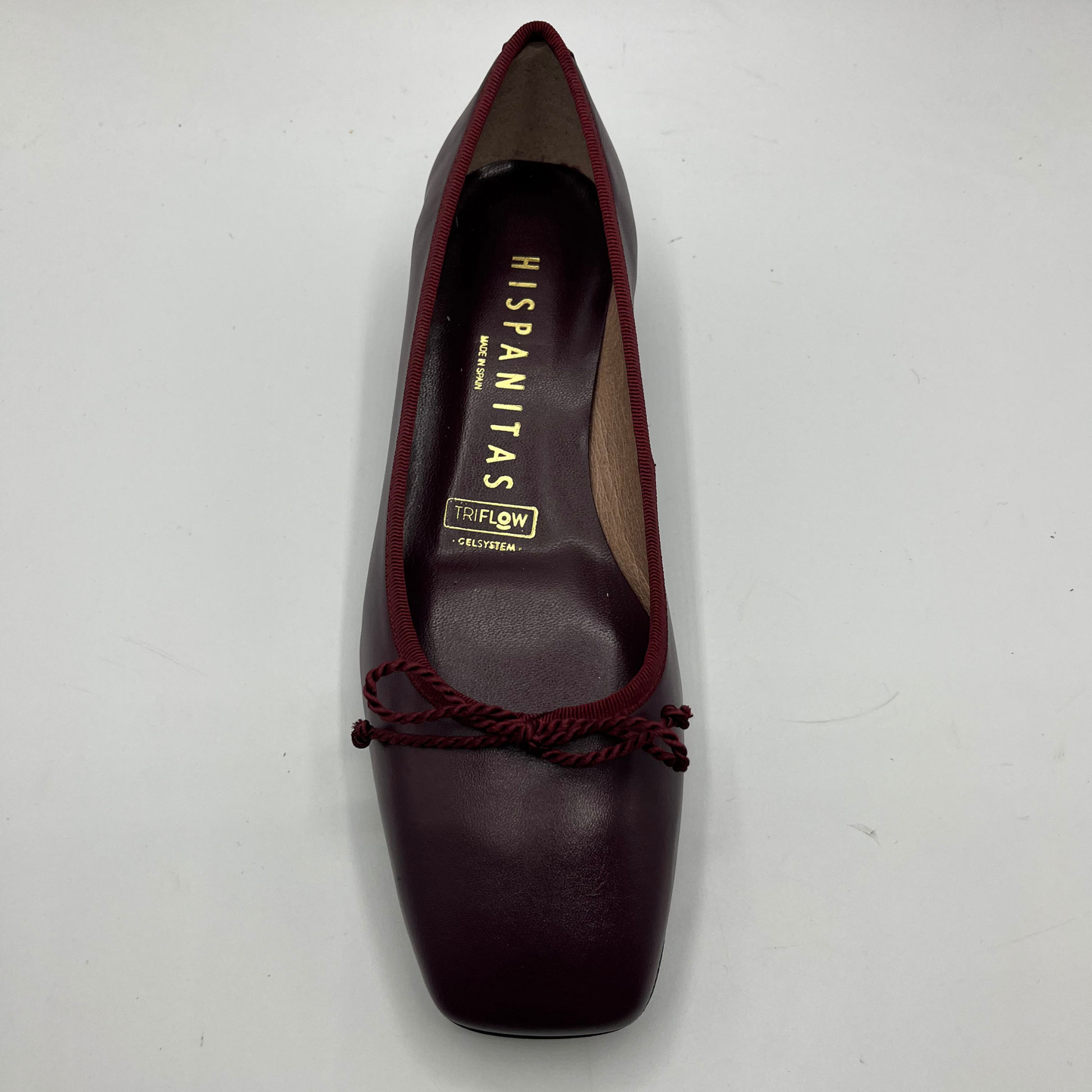 Maroon shoe with brand name on a white background