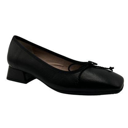 45 degree angled view of black ballet style pump with short block heel. Bow detail on upper and features a square toe