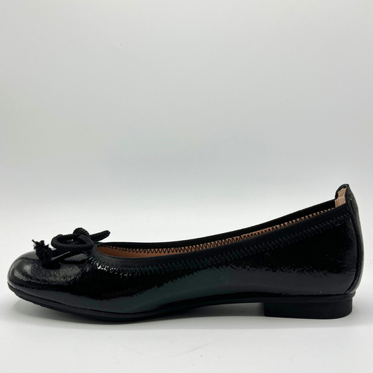 Black patent leather flat shoe on a white background