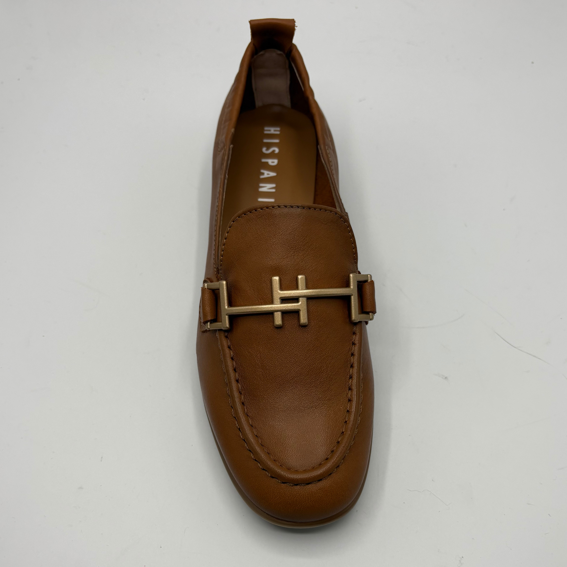 Brown loafer shoe with gold buckle on a white background
