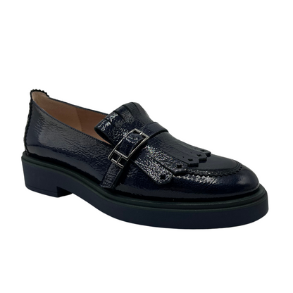 45 degree angled view of midnight blue leather loafer with low heel and adjustable buckle on upper.
