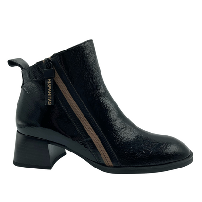 Side view of black patent leather ankle boot with gold zip closure