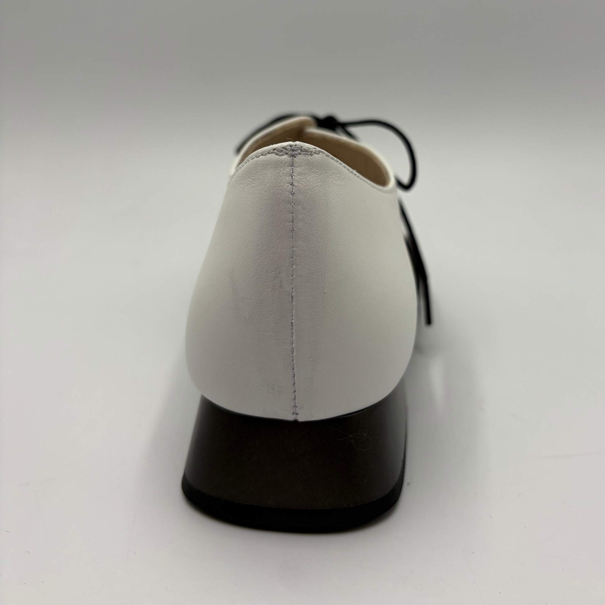 White shoe with black sole on a white background