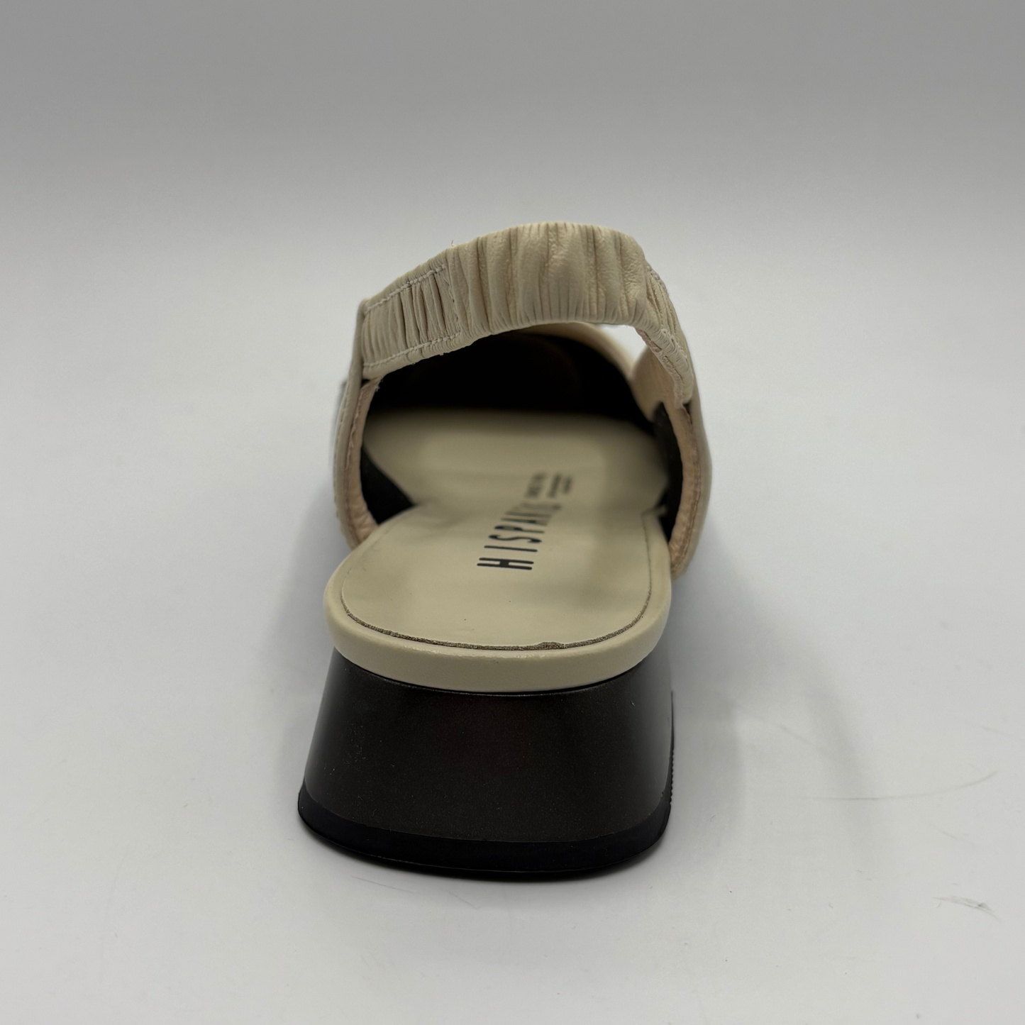 Beige sandal with a black sole on a white background