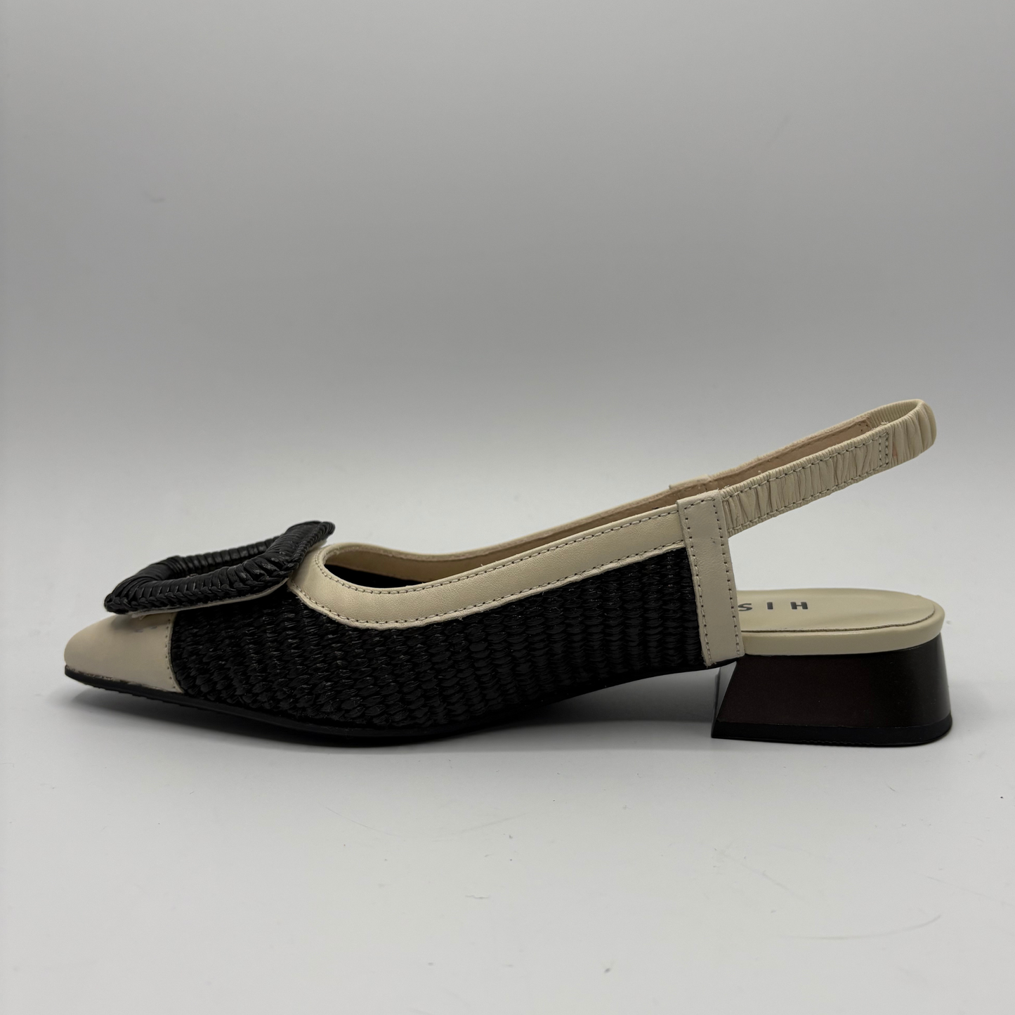 Black and beige sandal with woven design on a white background