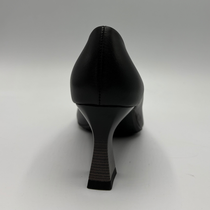 A black leather high-heeled shoe shown from the back, featuring a pointed toe and a chunky block heel, set against a neutral gray background.