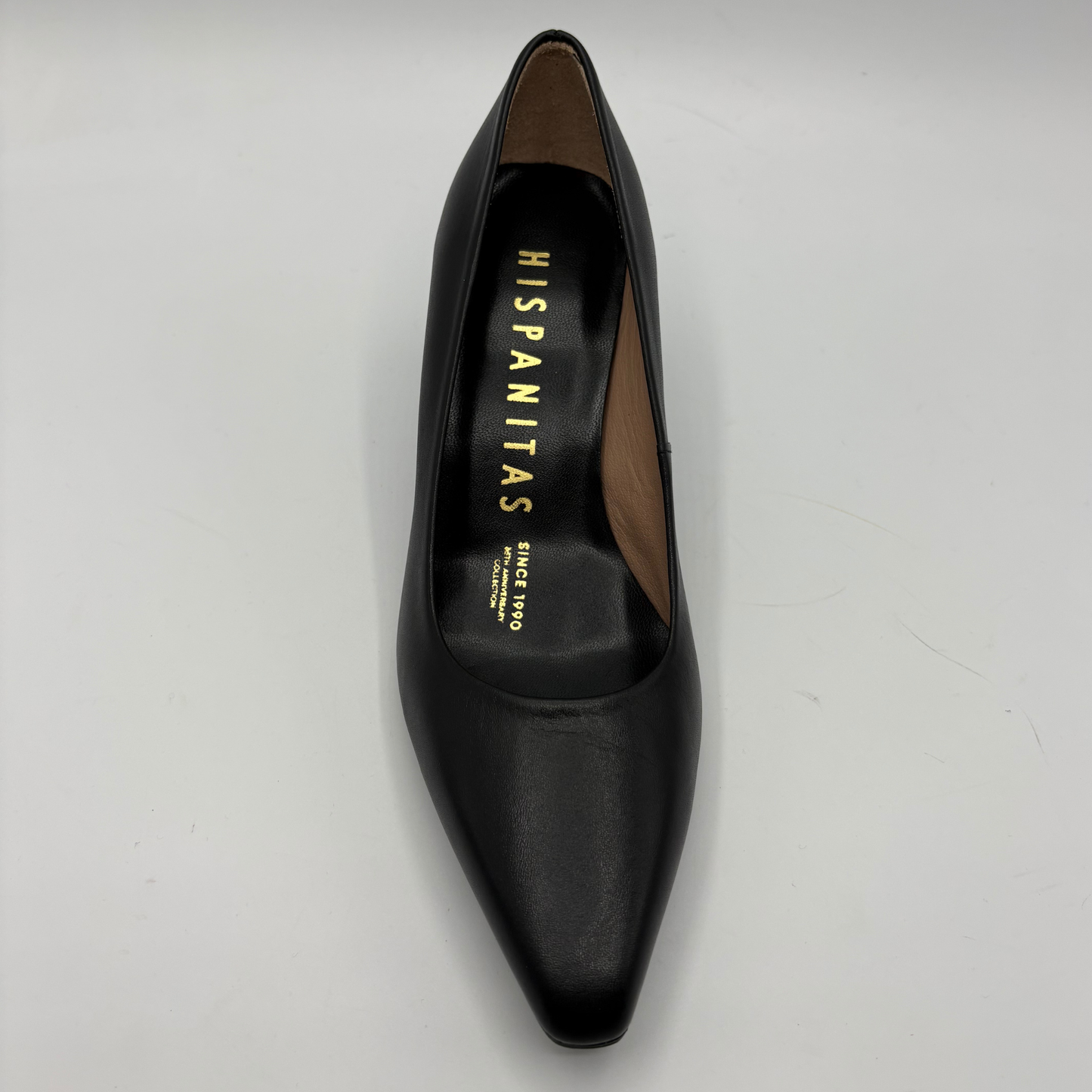 A single black leather pointed-toe pump shoe by Hispanitas, shown from a top-down angle on a light gray background.