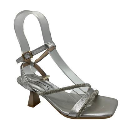 Angled view of silver leather strappy  sandal with a flared kitten heel and embellished accent straps.