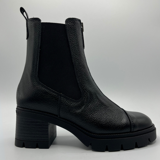 Black leather boot on a light gray background