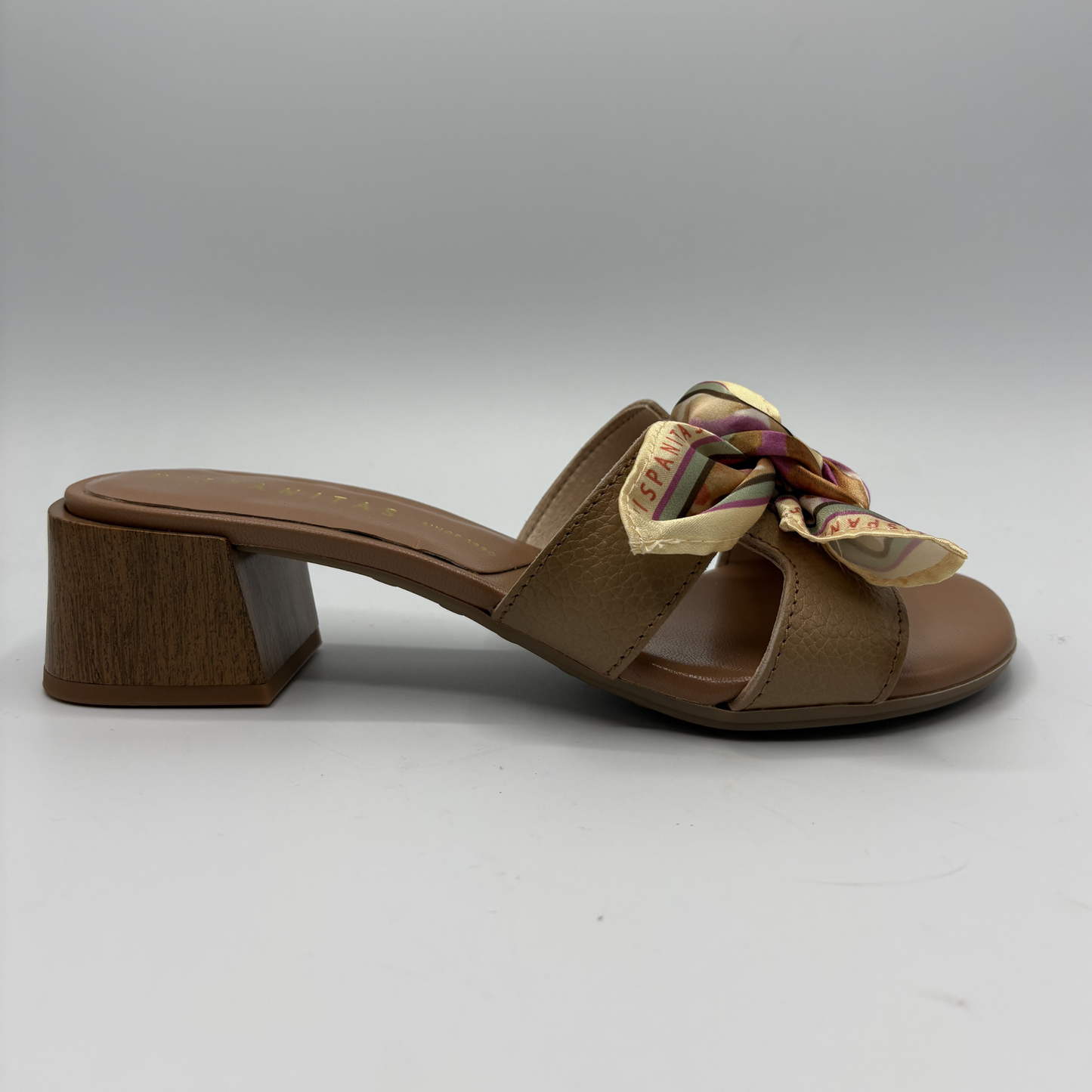 Brown sandal with a decorative bow on a gray background
