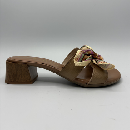 Brown sandal with a decorative bow on a gray background