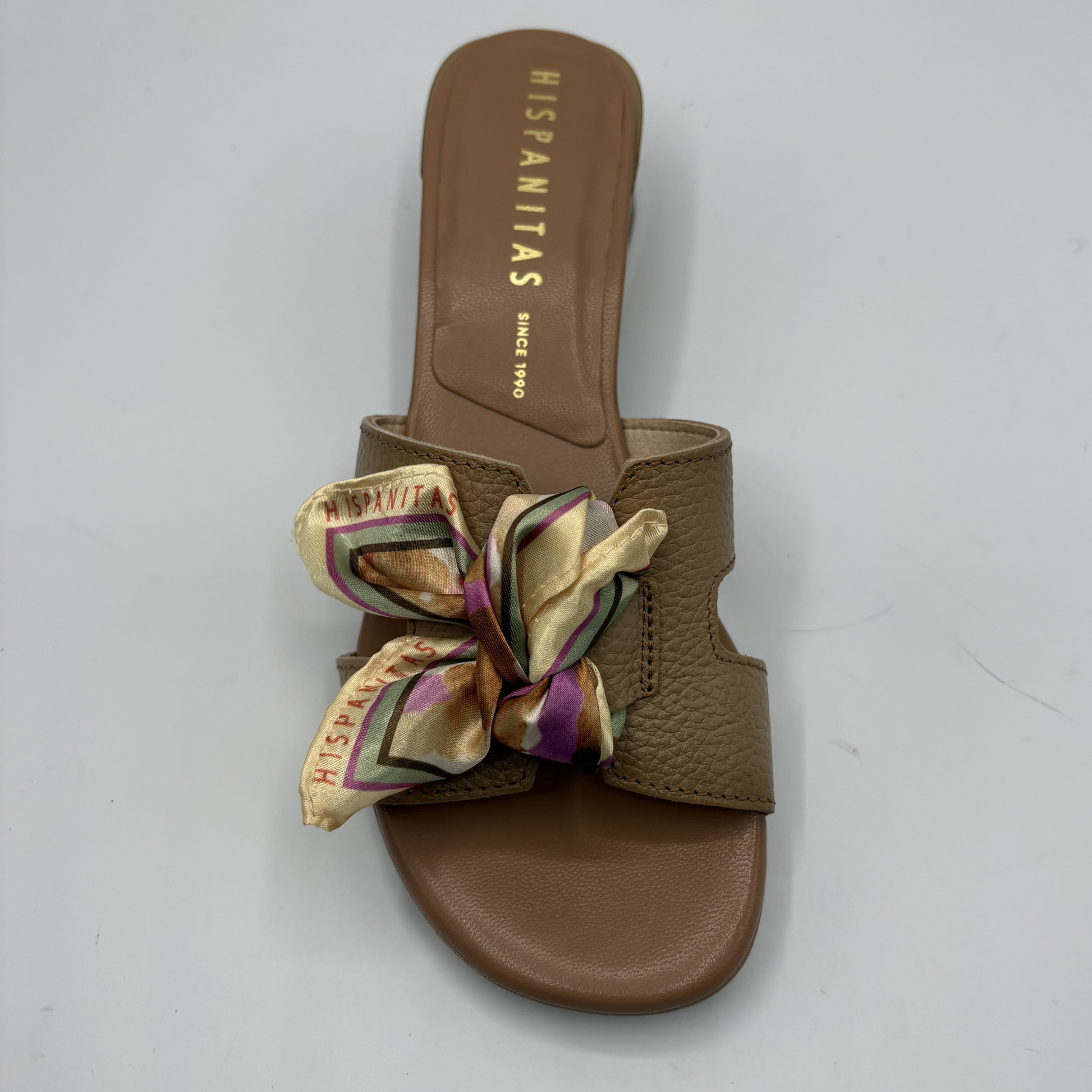 Brown sandal with a decorative bow on a white background