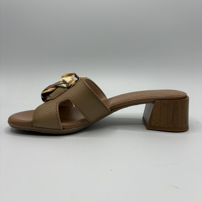 Brown sandal with a decorative strap on a white background