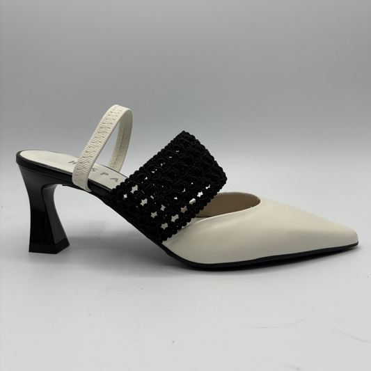 White high-heeled shoe with black embellished strap on a gray background