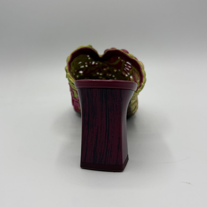 Green, pink and yellow high heeled shoe on a grey background