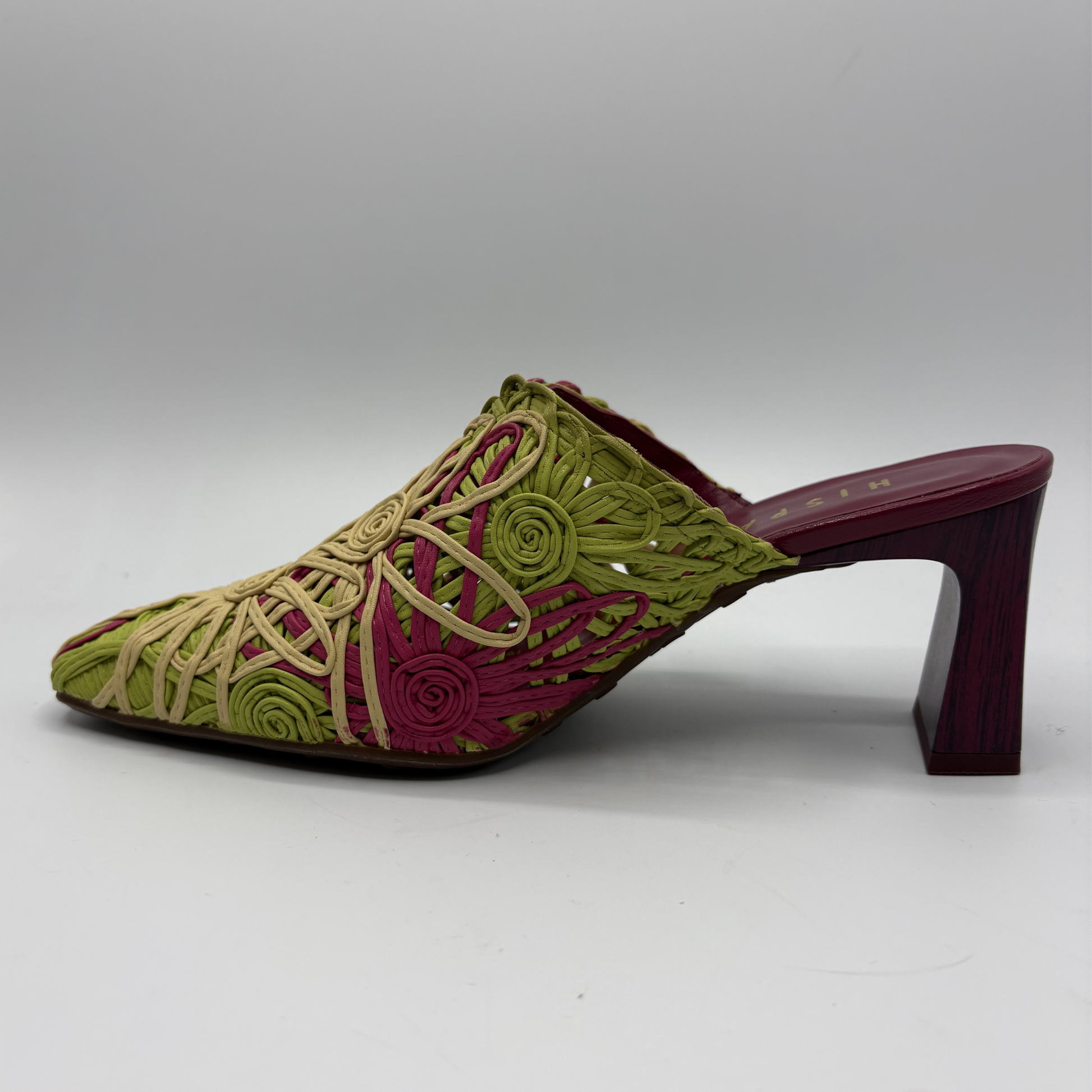Green and red embroidered shoe on a gray background