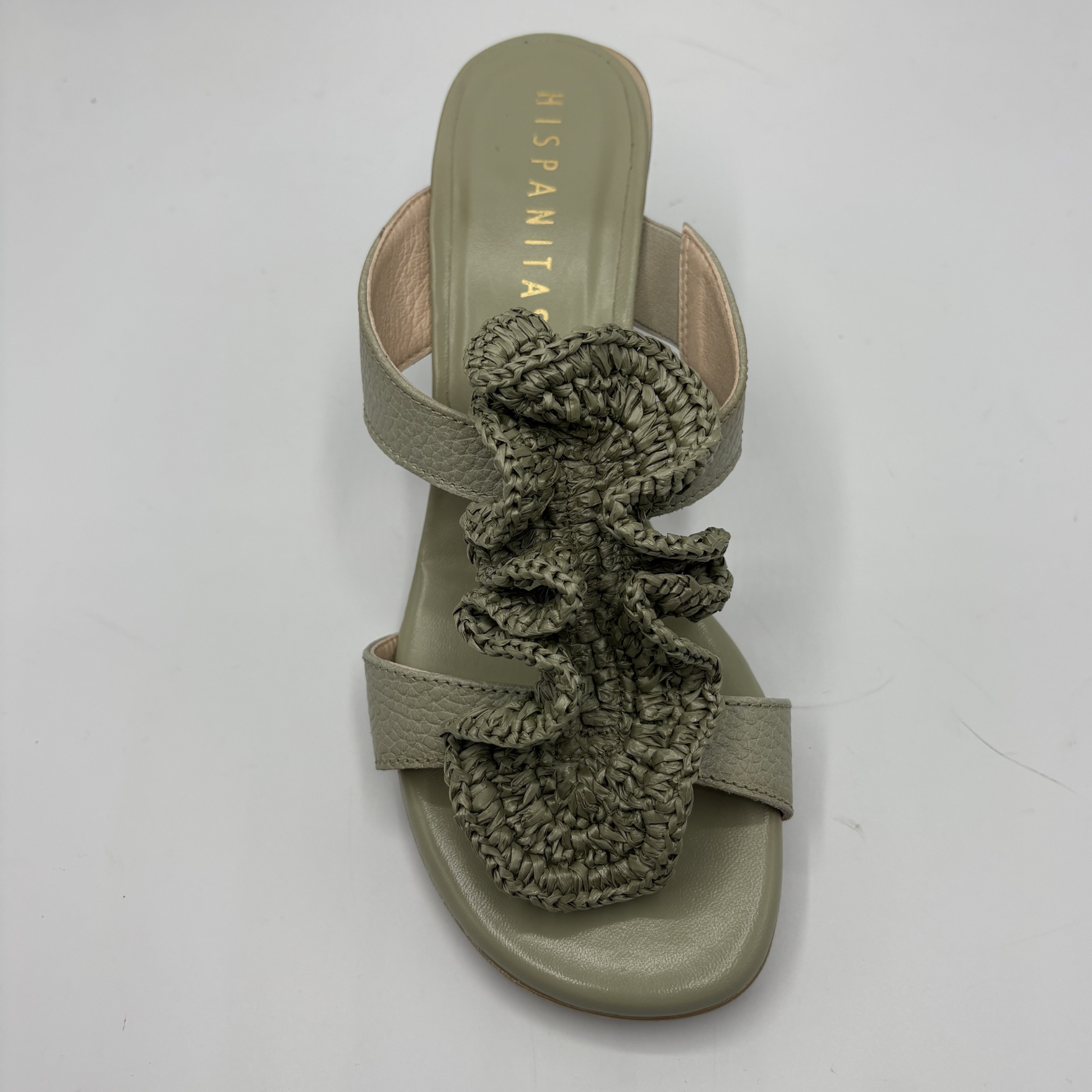Green sandal with ruffled design on a white background