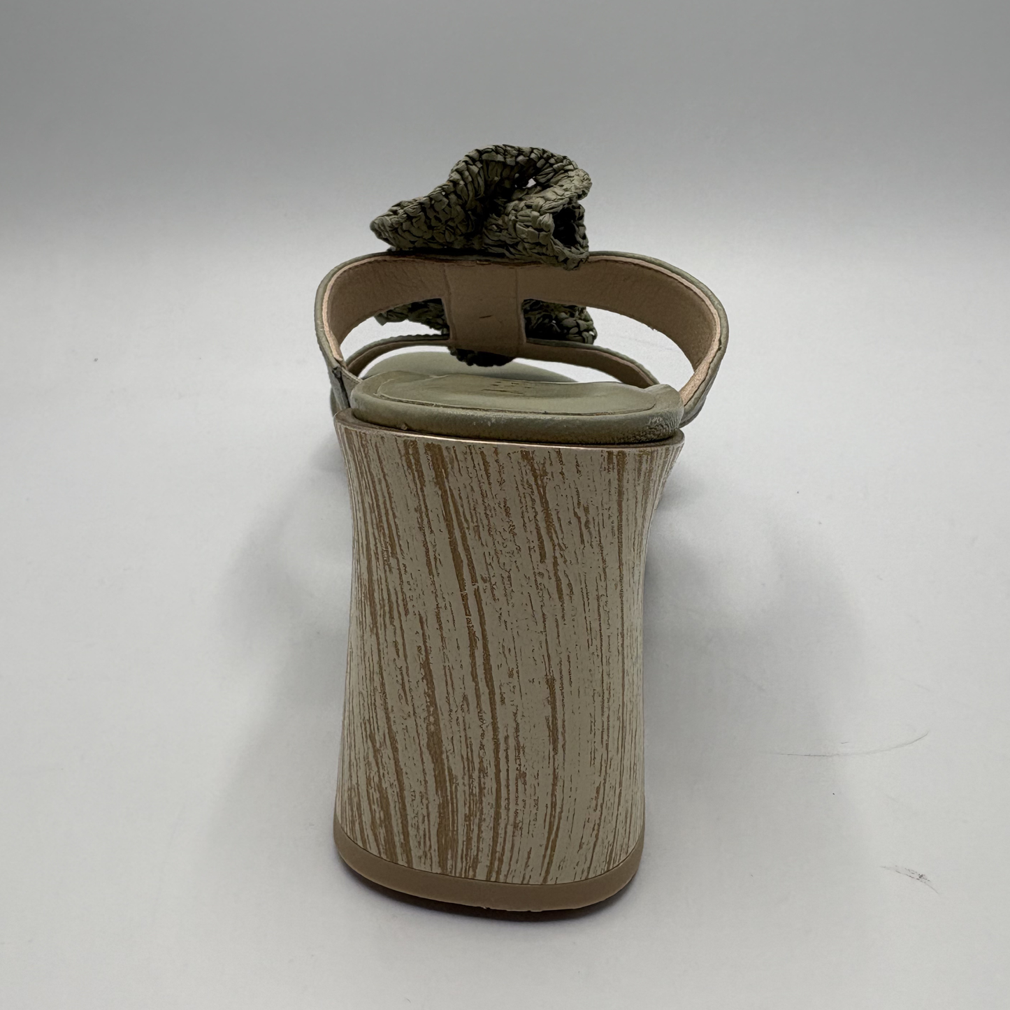 Green sandal with ruffled design on a white background