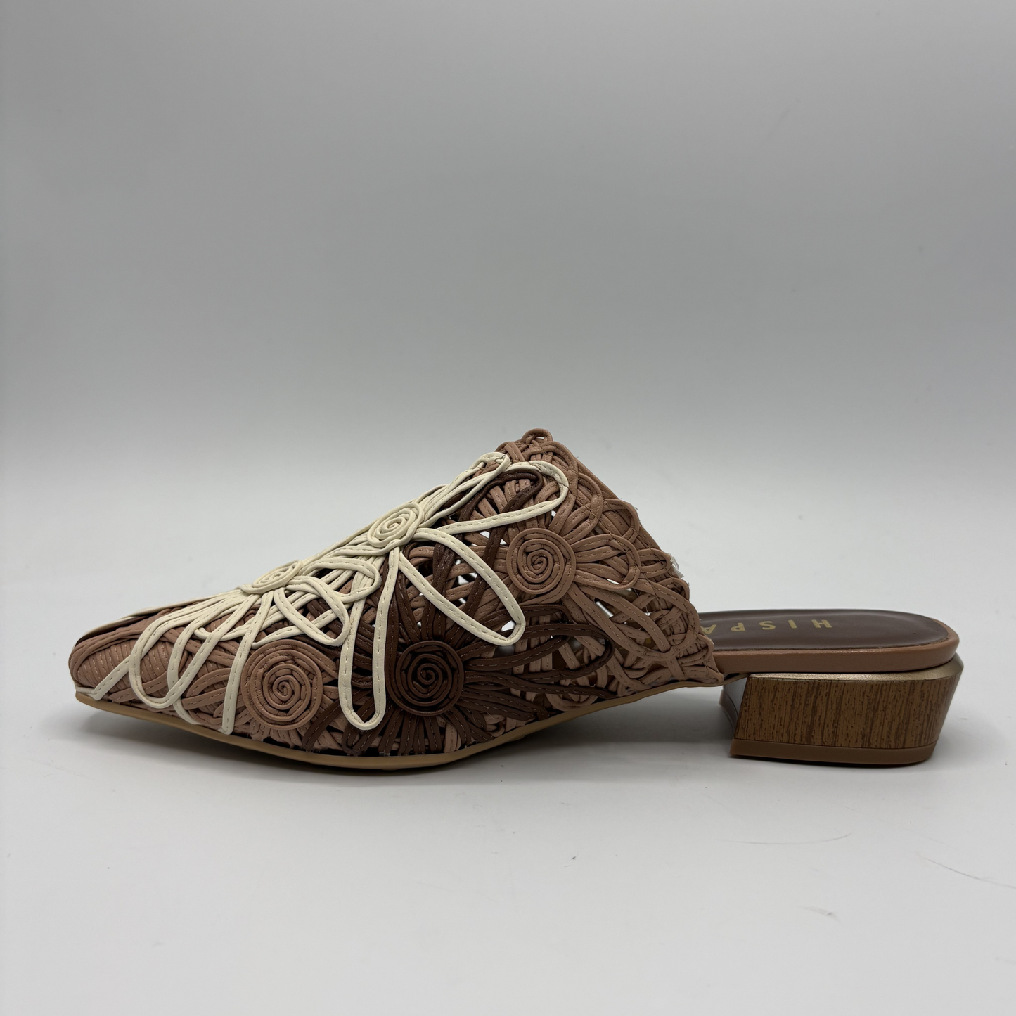 Brown embroidered shoe with white embroidery on a gray background