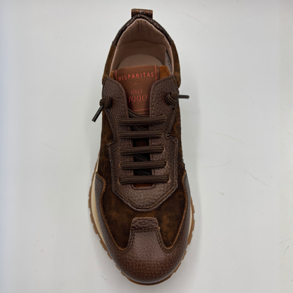 A brown suede and textured leather sneaker shown from a top-down view on a light gray background. The shoe features matching brown laces, a textured toe cap, and a tan interior lining with 'HISPANITAS' printed on the insole.