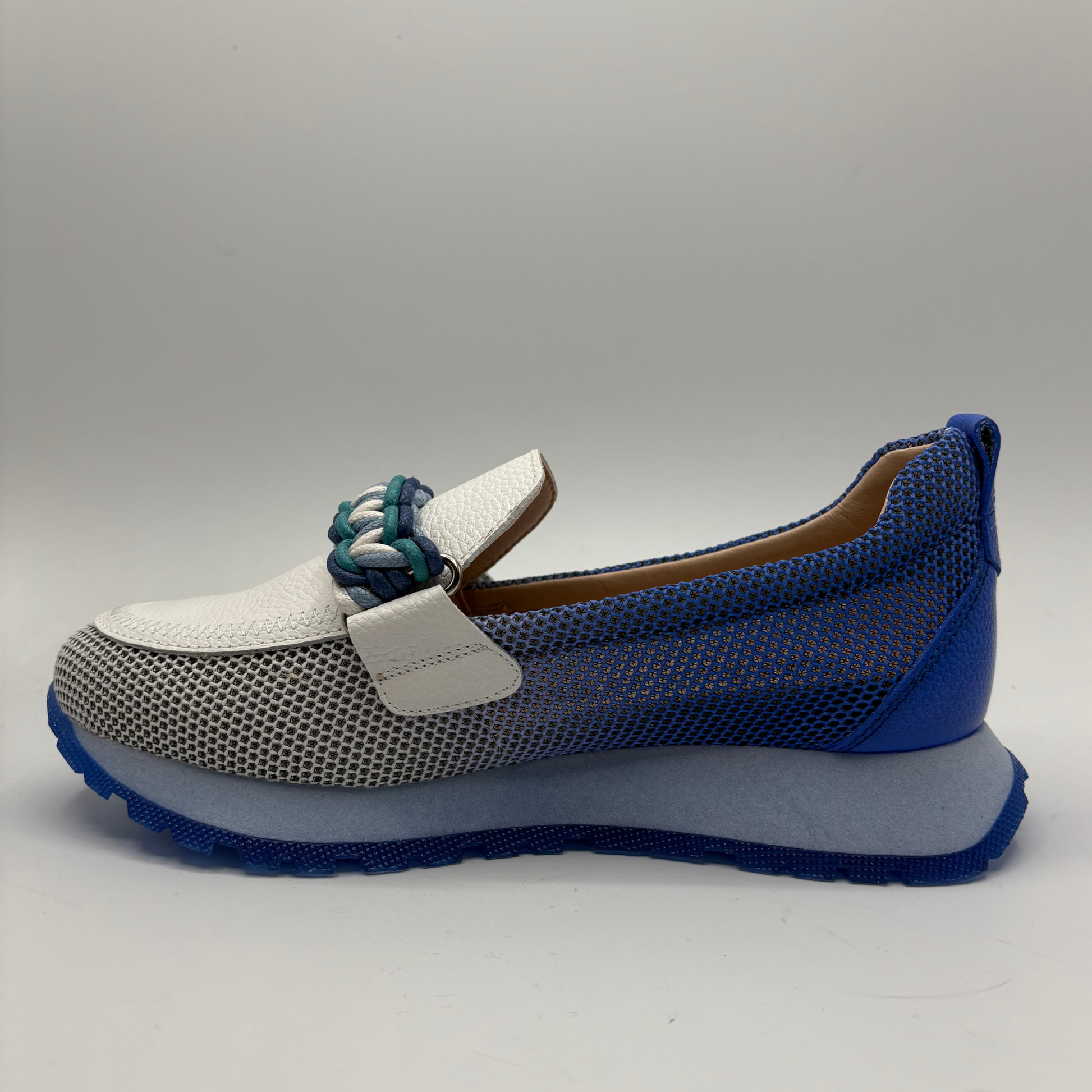 Blue and white shoe with textured sole on a gray background