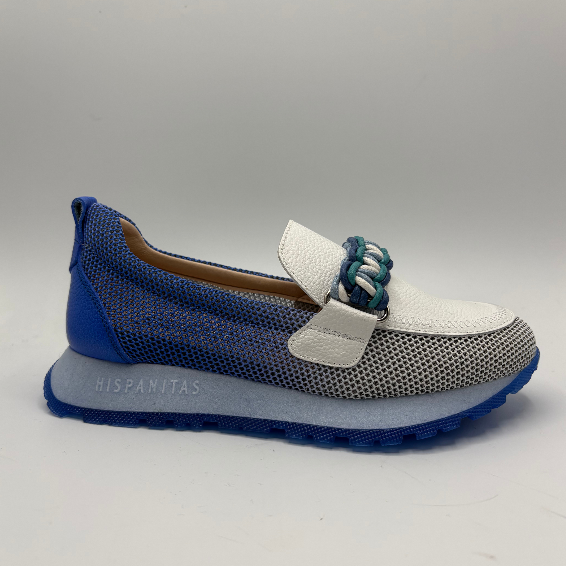 Blue and white shoe with textured sole on a gray background