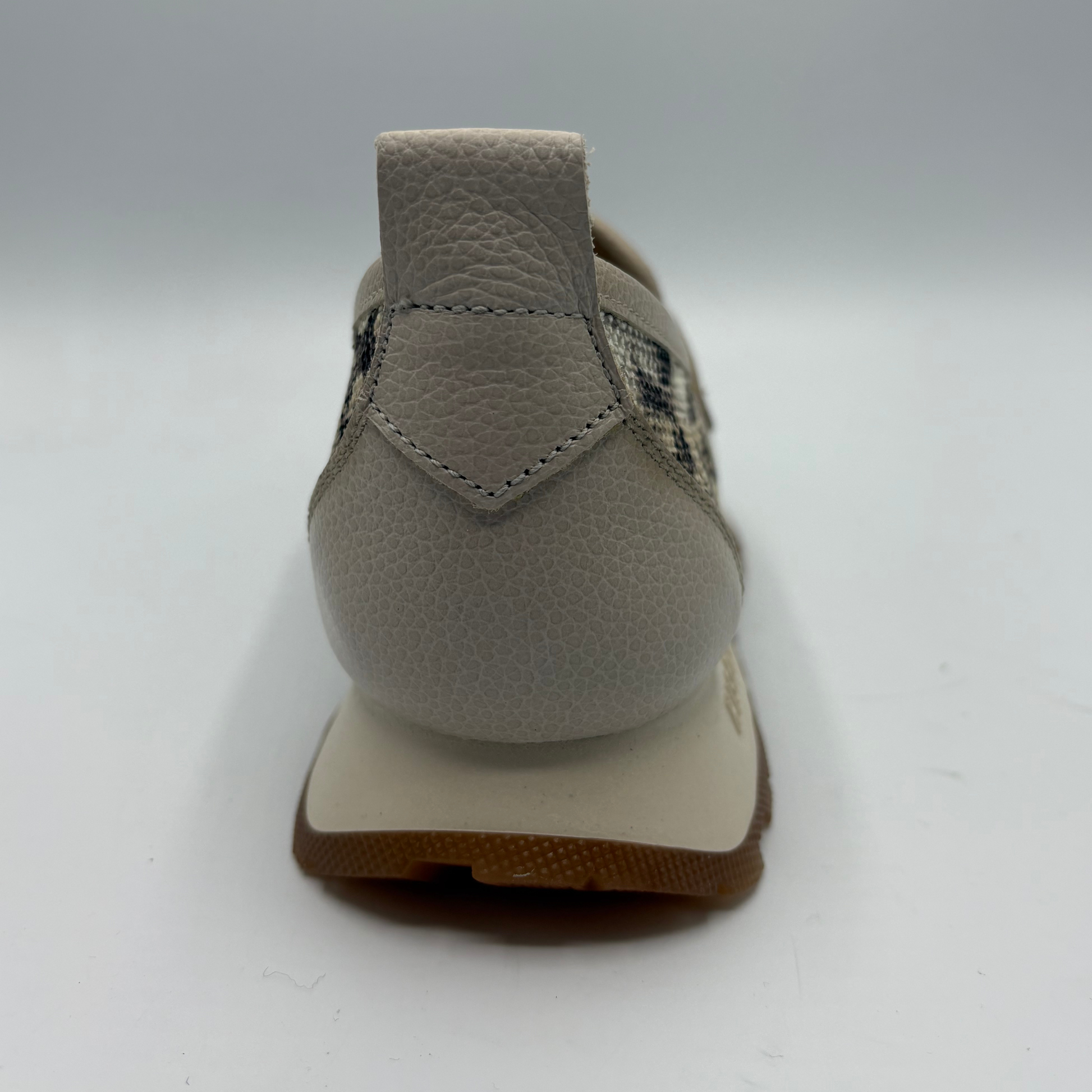 Gray shoe with a textured sole on a white background