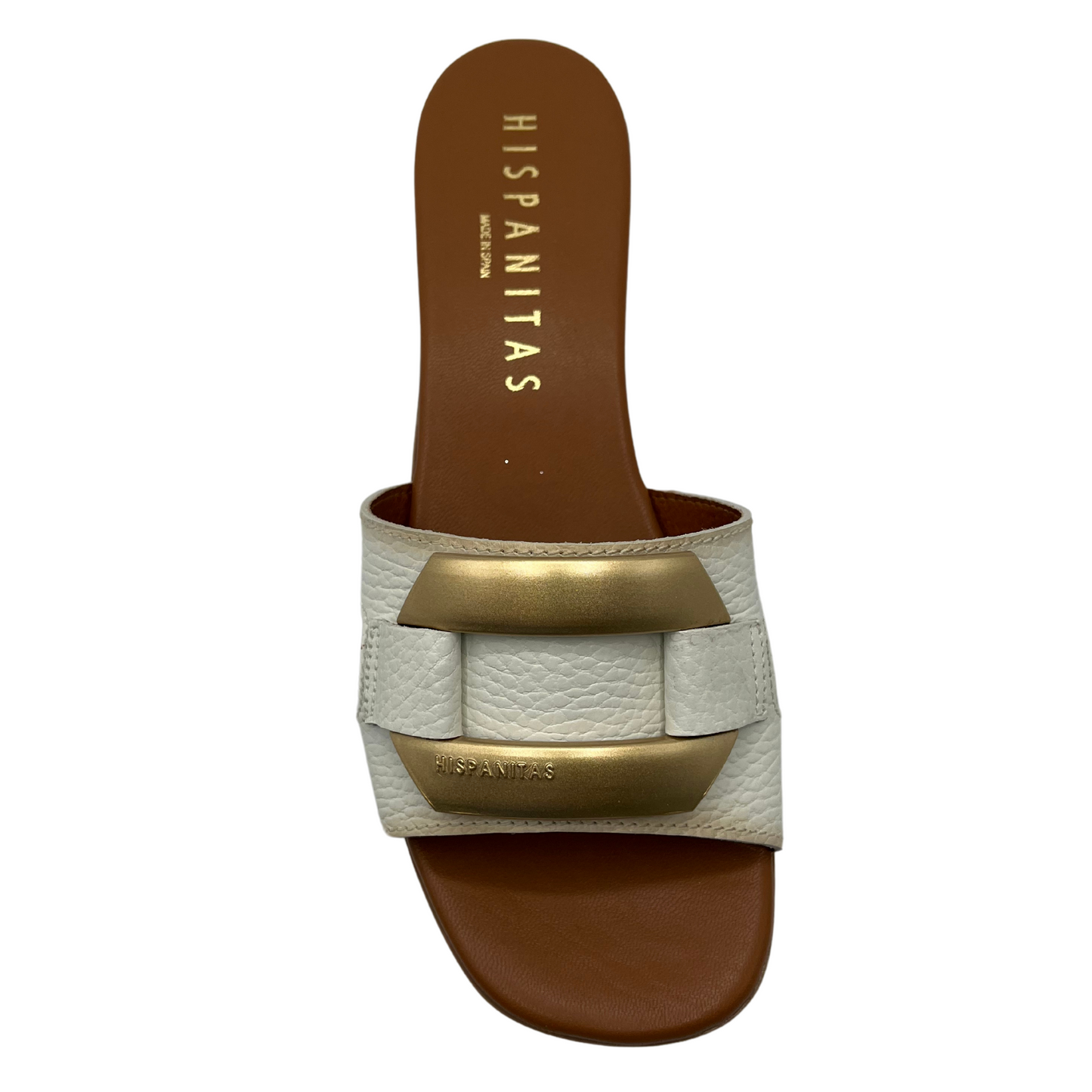 Top view of white and brown leather sandal with gold brooch detail on upper