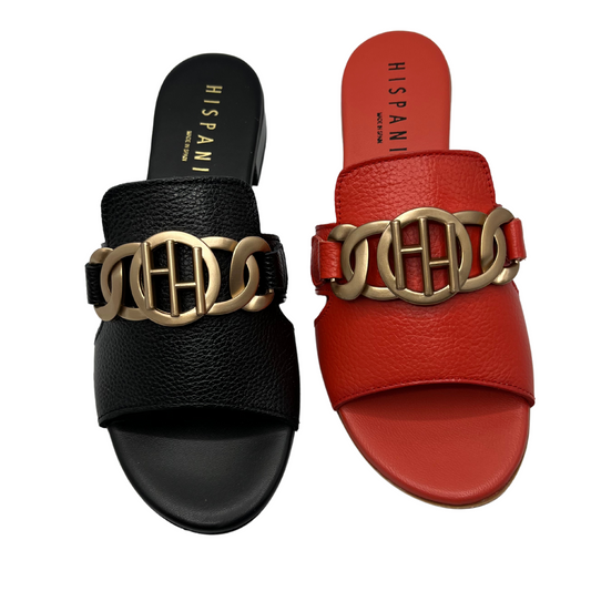 Top view of two leather sandals beside each other. One is black and one is scarlett. Both have gold details, slip on style with leather lining.