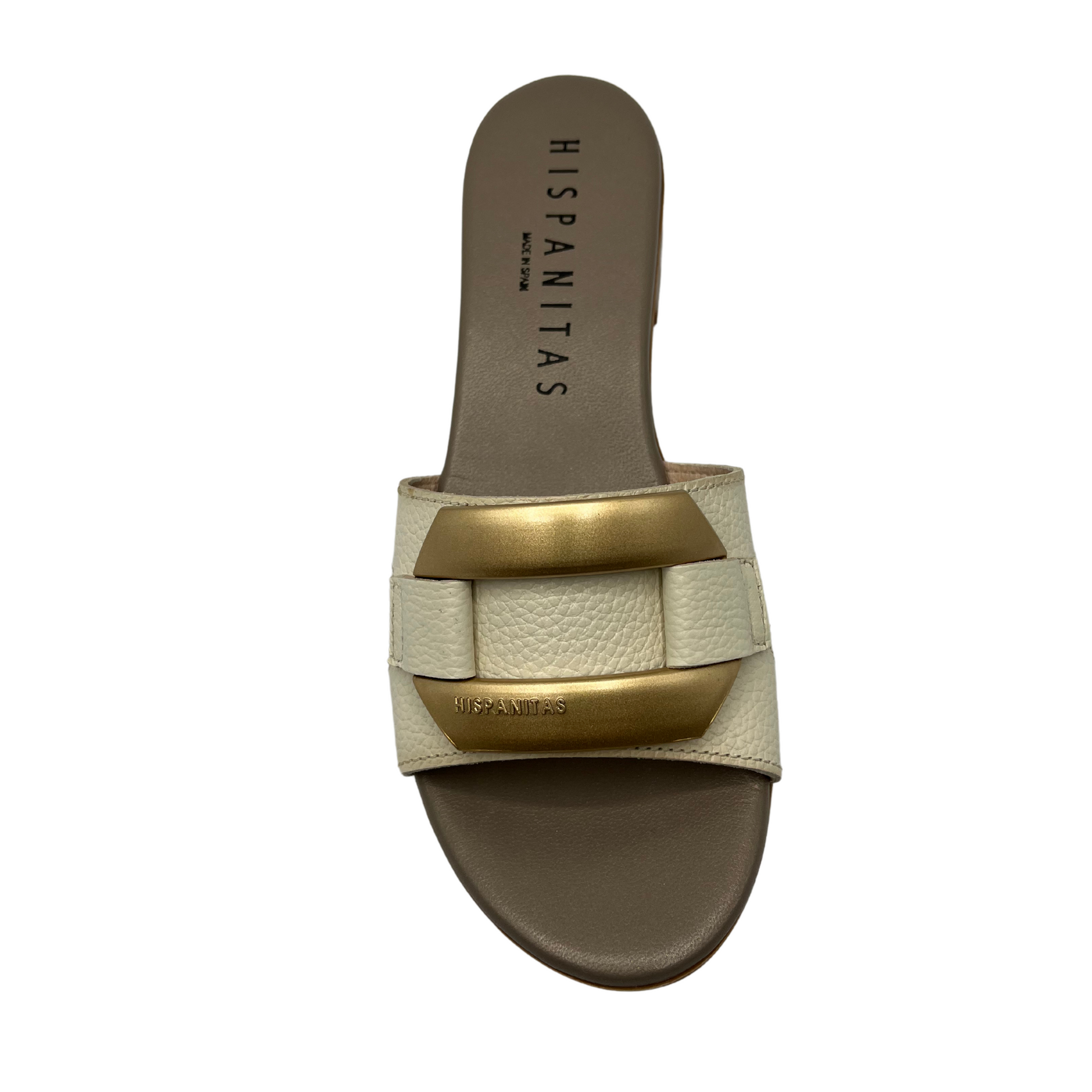 Top view of slip on sandal with a cream coloured leather strap. Leather lined, short block heel and gold detail on upper.