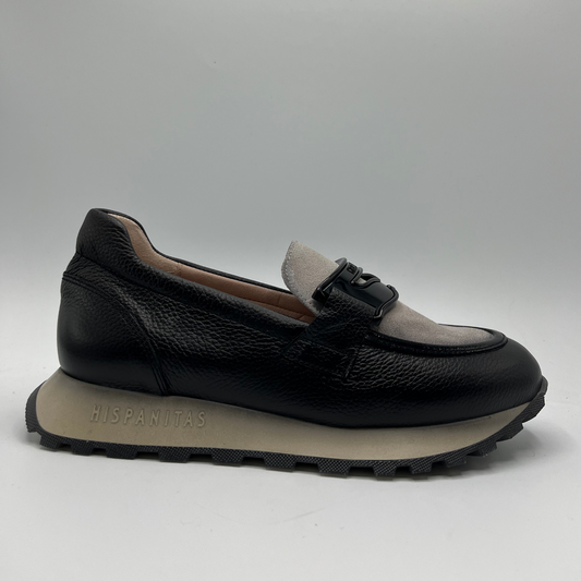 Black loafer shoe with beige lining on a gray background