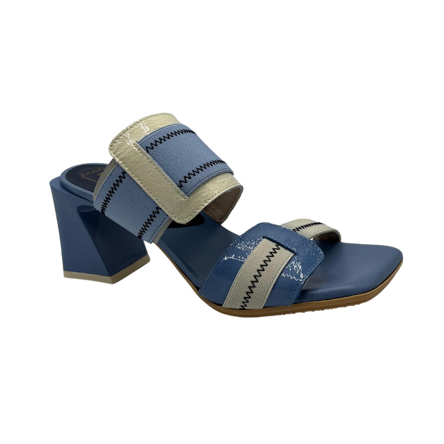 Angled view of blue and natural leather and elastic slip on sandal. Featuring a square toe and unique block heel.