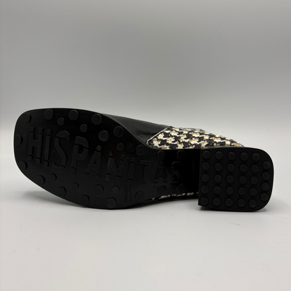 The outsole and heel of a black slip-on shoe, showing the brand name 'HISPANITAS' embossed on the black tread and a black, white, and beige houndstooth pattern on the heel counter, set against a neutral gray background.