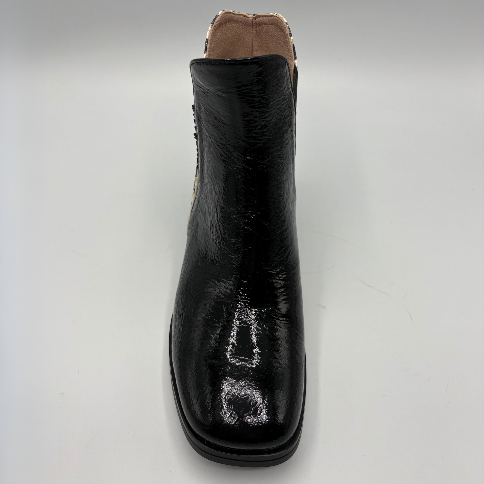 A single black leather ankle boot with a glossy finish, shown from a front-facing perspective on a light gray background.