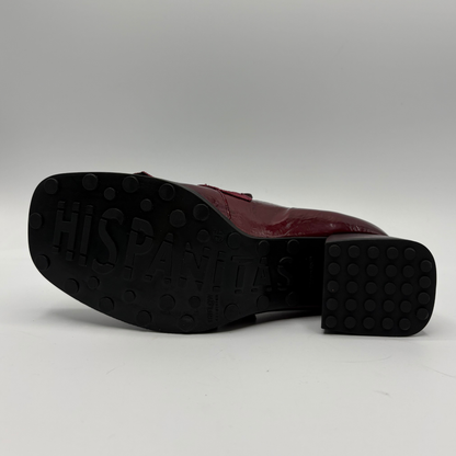 A single burgundy leather shoe shown from the side, with its black rubber outsole facing the camera. The outsole has 'HISPANITAS' embossed on it, indicating the brand.