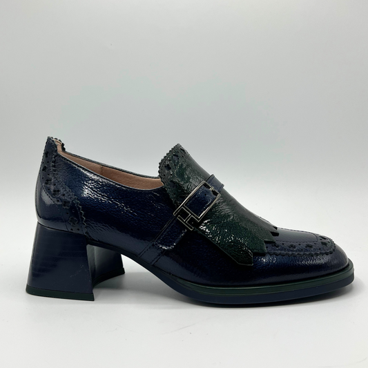 Navy blue leather shoe with a buckle on a light gray background